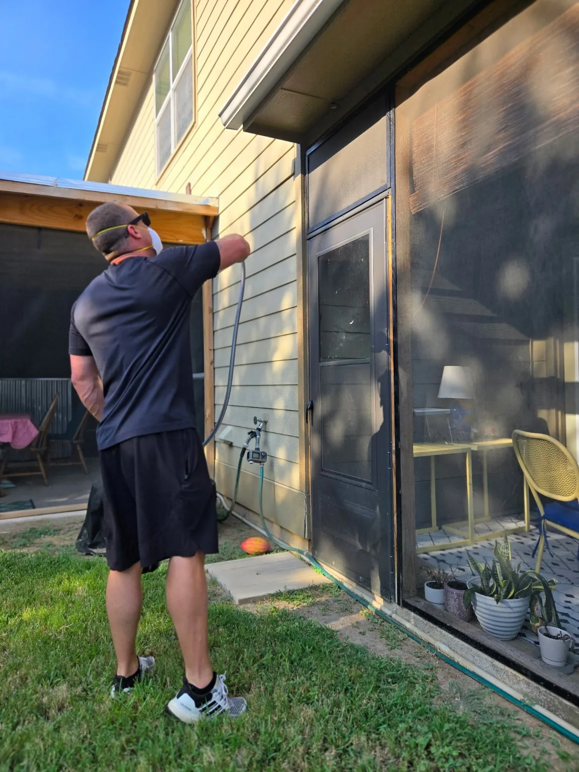 Bug Lock treating a screened patio enclosure during residential pest control service