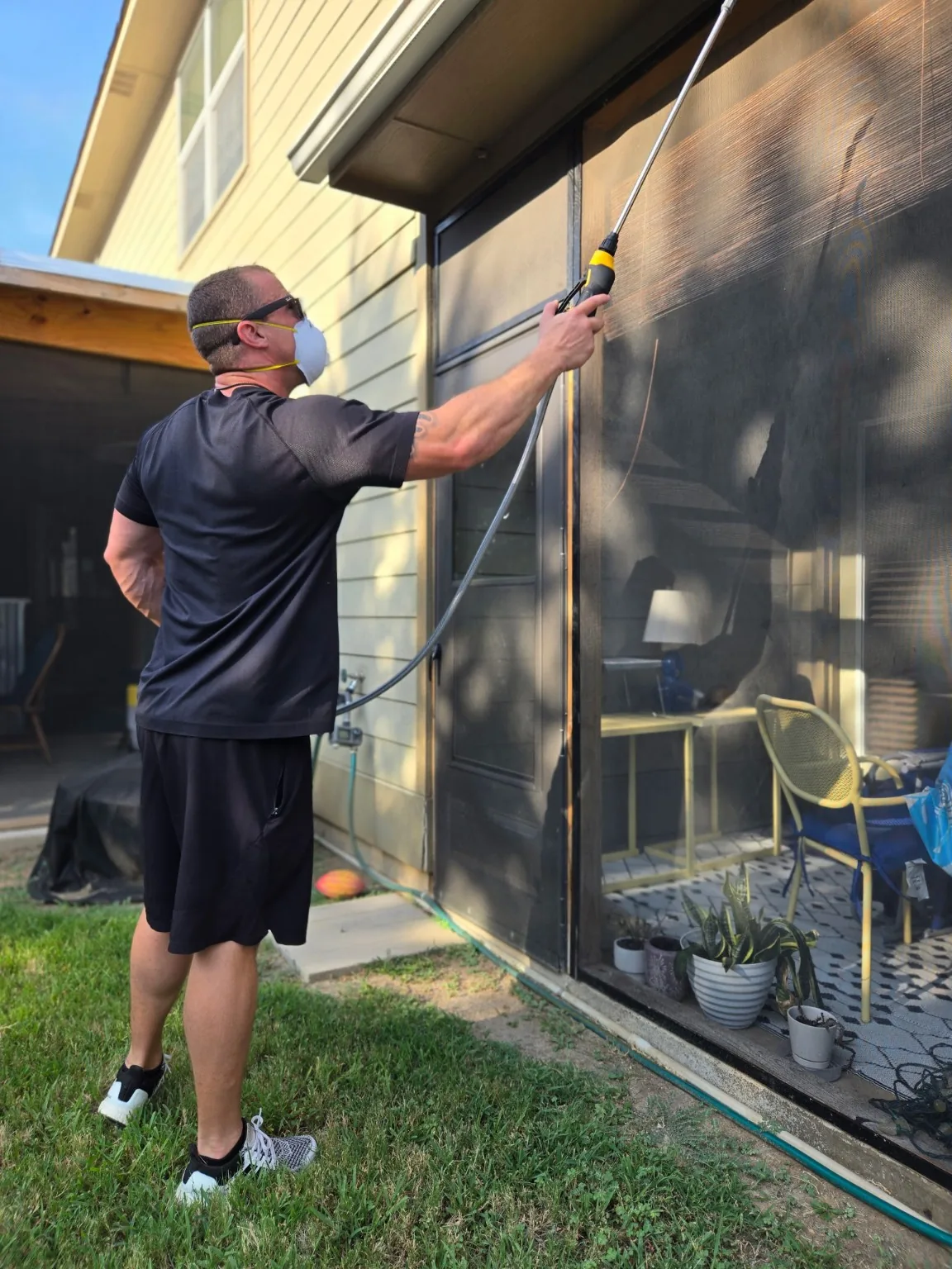 Bug Lock applying pest control around a screened outdoor living area