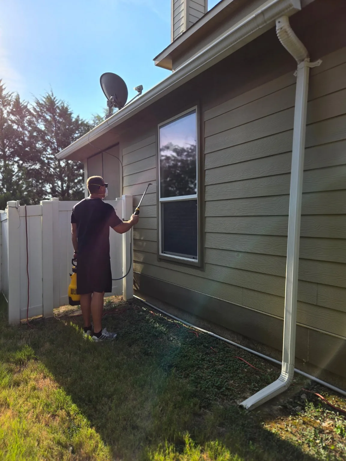 Bug Lock owner applying an exterior pest control treatment to a North Texas home